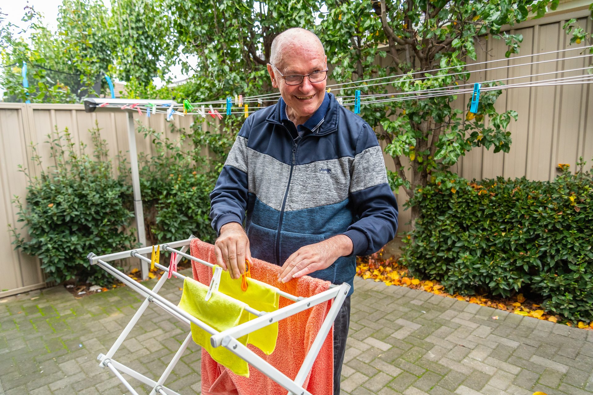 Man in blue jumper hanging out washing