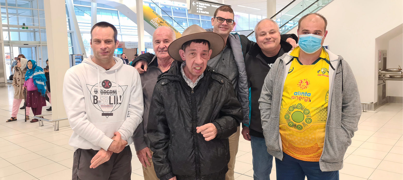 Six male clients eagerly waiting at Adelaide Airport for their flight to Queensland. 