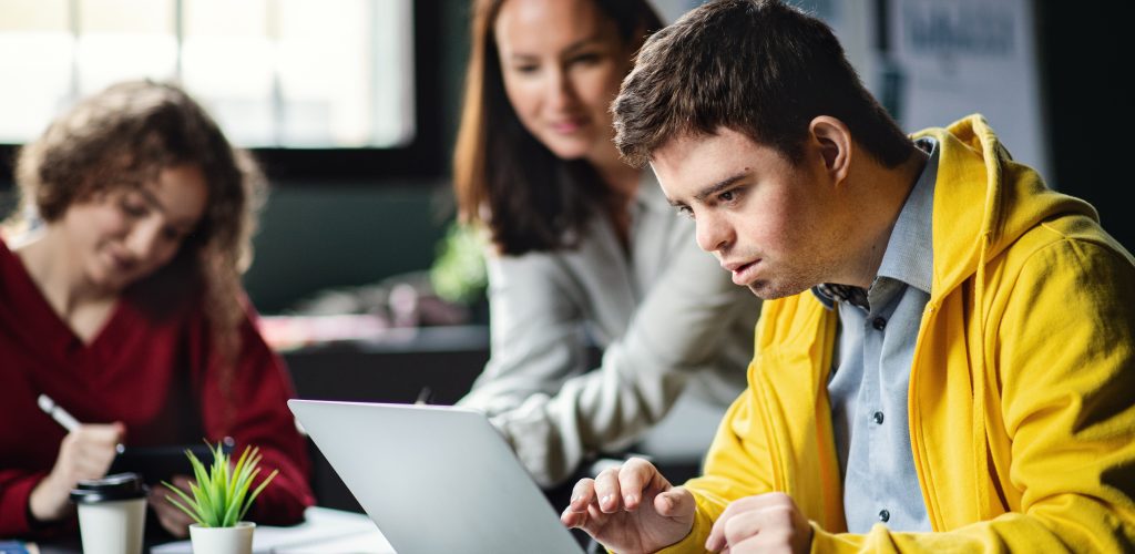 Man in yellow jacket working on a laptop